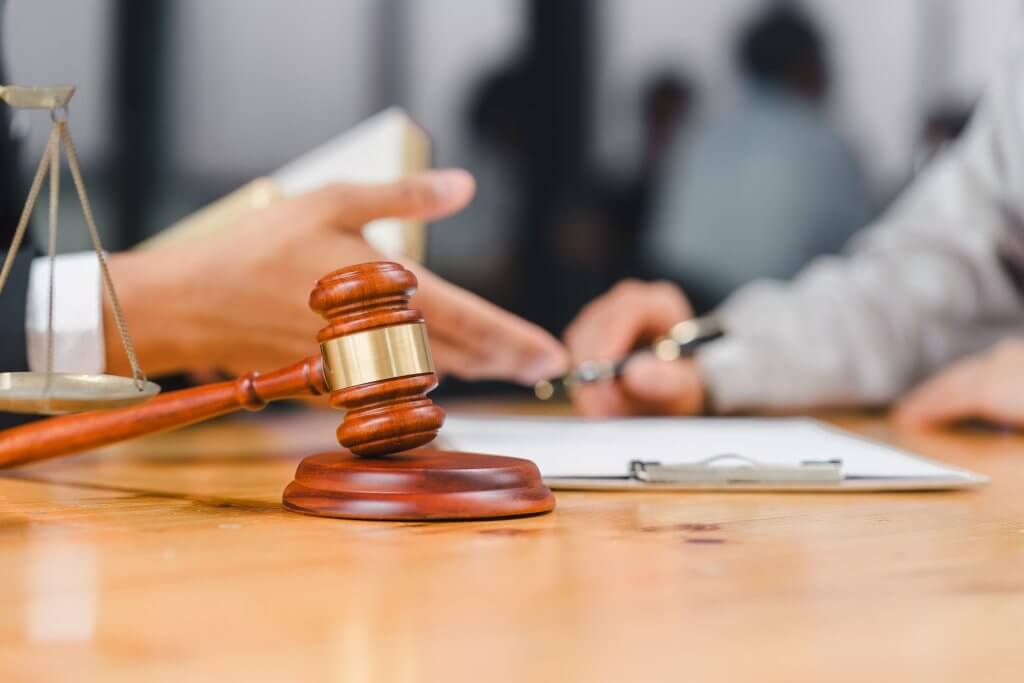 Attorney examining wage and hour records beside a gavel and scales of justice