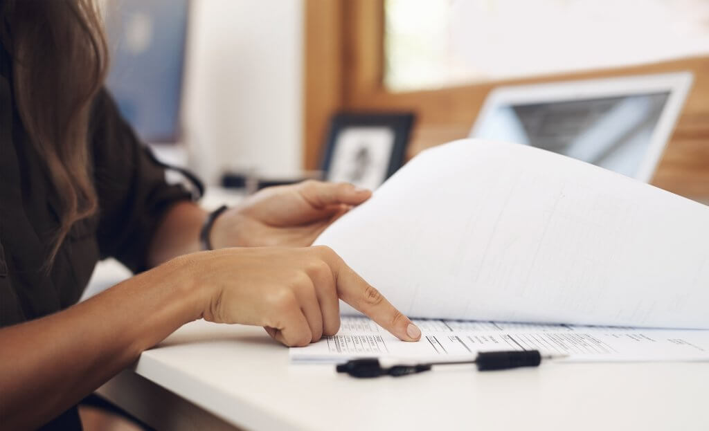 Reviewing payroll records and tax documents at a desk