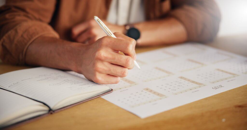 Worker writing down dates and details of workplace incidents in a notebook
