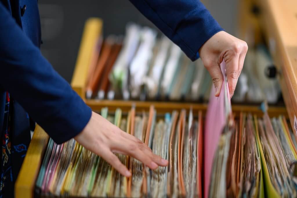 Employment records being retrieved from a file drawer