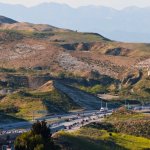 Freeway winding through dry hills in the Inland Empire, connecting workers across Riverside and San Bernardino counties