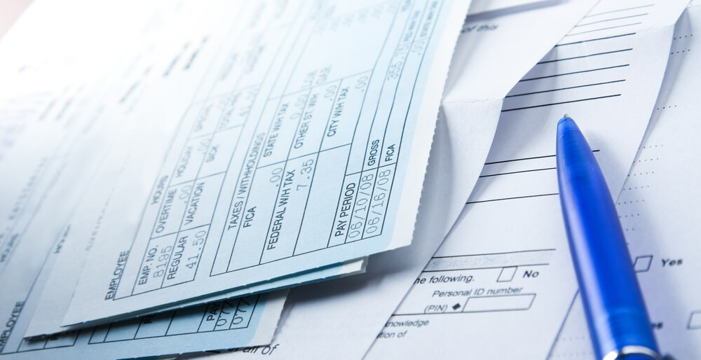 Worker reviewing a final pay stub, which California law requires to include all earned wages at termination