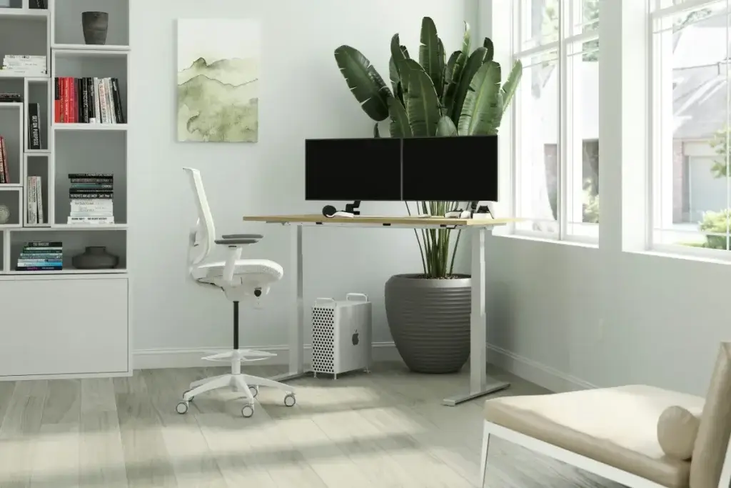 Adjustable standing desk in a bright office, an example of a California reasonable accommodation at work