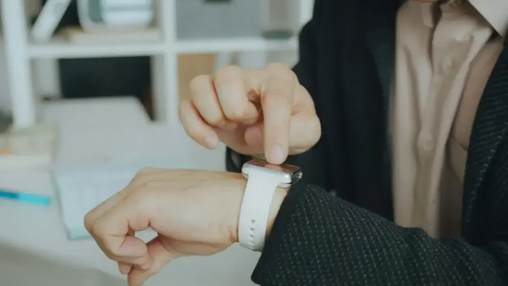 Worker checking the time on a smartwatch, tracking hours that can count as off the clock work in California