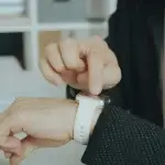 Worker checking the time on a smartwatch, tracking hours that can count as off the clock work in California