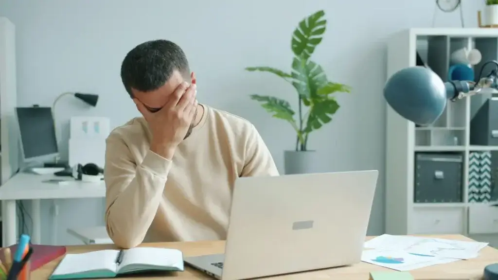 Stressed California employee at his desk worried about the average settlement for a retaliation lawsuit