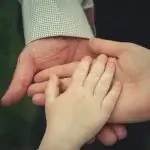 Three generations of family members holding hands, representing who can file a wrongful death claim in California.