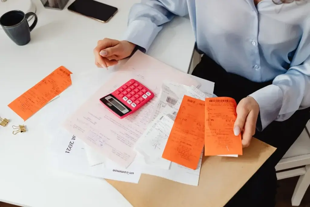 Person using a calculator and receipts to compare workers comp and state disability payments
