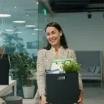 Employee packing personal items into a box after losing a job in California.