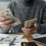 Worker counting cash pay under the minimum wage in California 2027