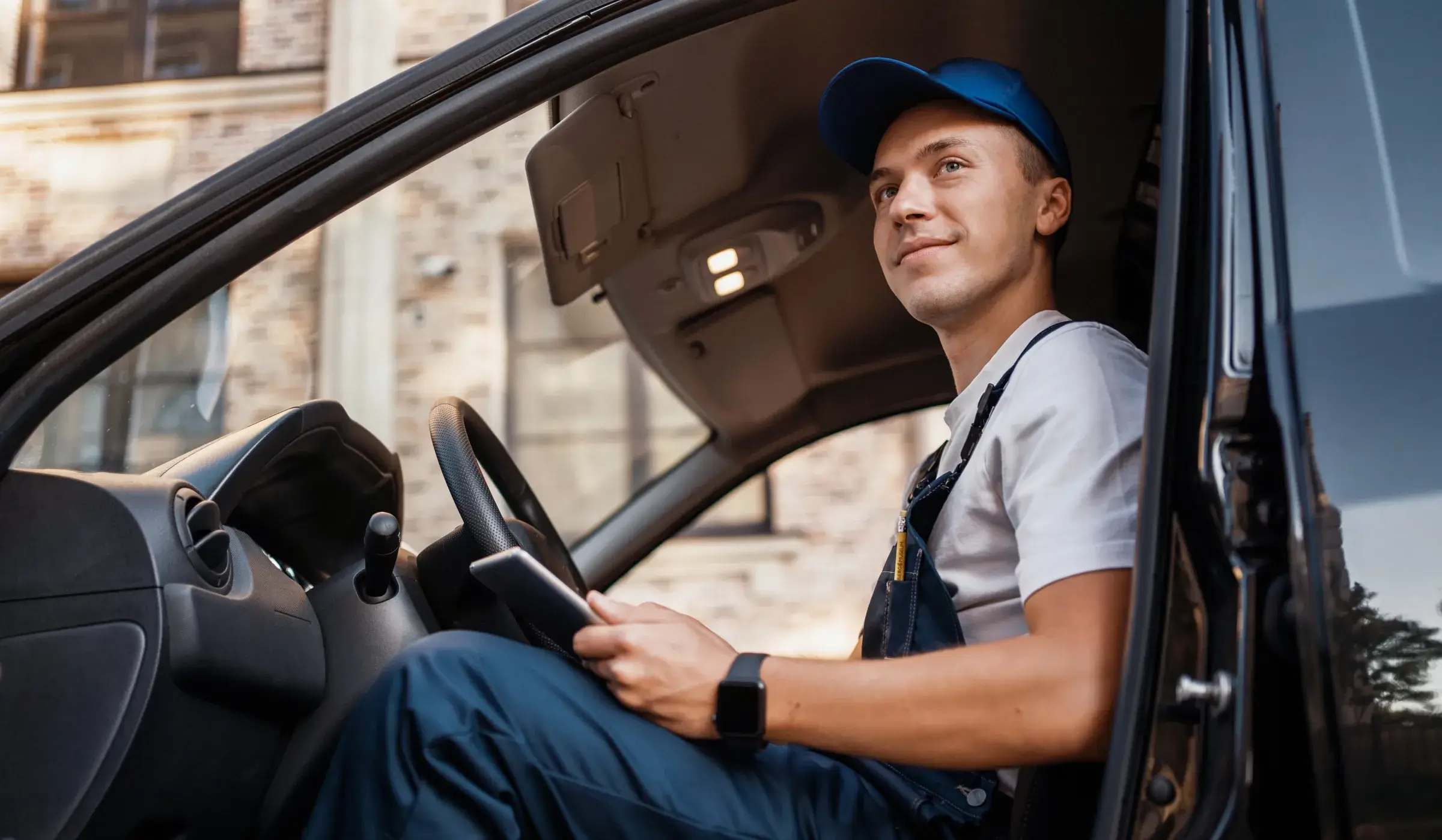 Delivery driver seated behind the wheel of a work van