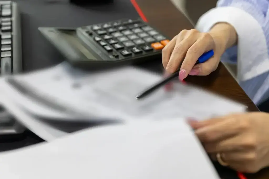 Employee using a calculator to compare a severance offer with the value of a claim