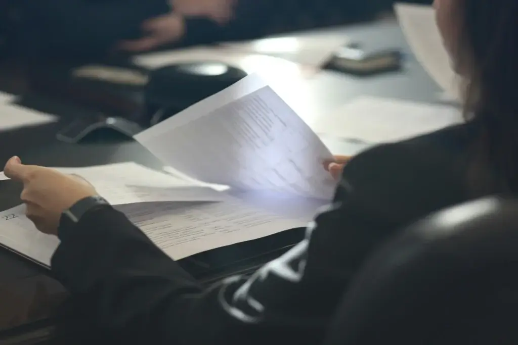 Employee reviewing printed documents at a table before deciding to sue your employer while still employed