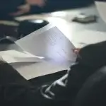 Employee reviewing printed documents at a table before deciding to sue your employer while still employed